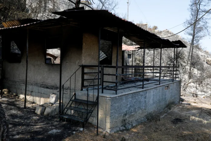 Πυρόπληκτη περιοχή με κατεστραμμένα σπίτια